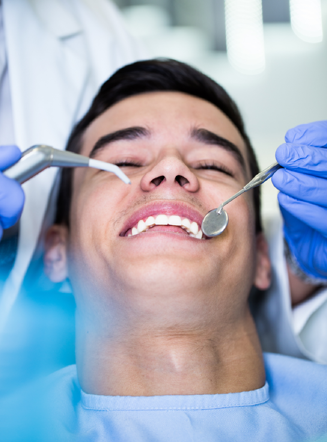 A man in a dental chair, mouth open, ready for a dental procedure or check-up.